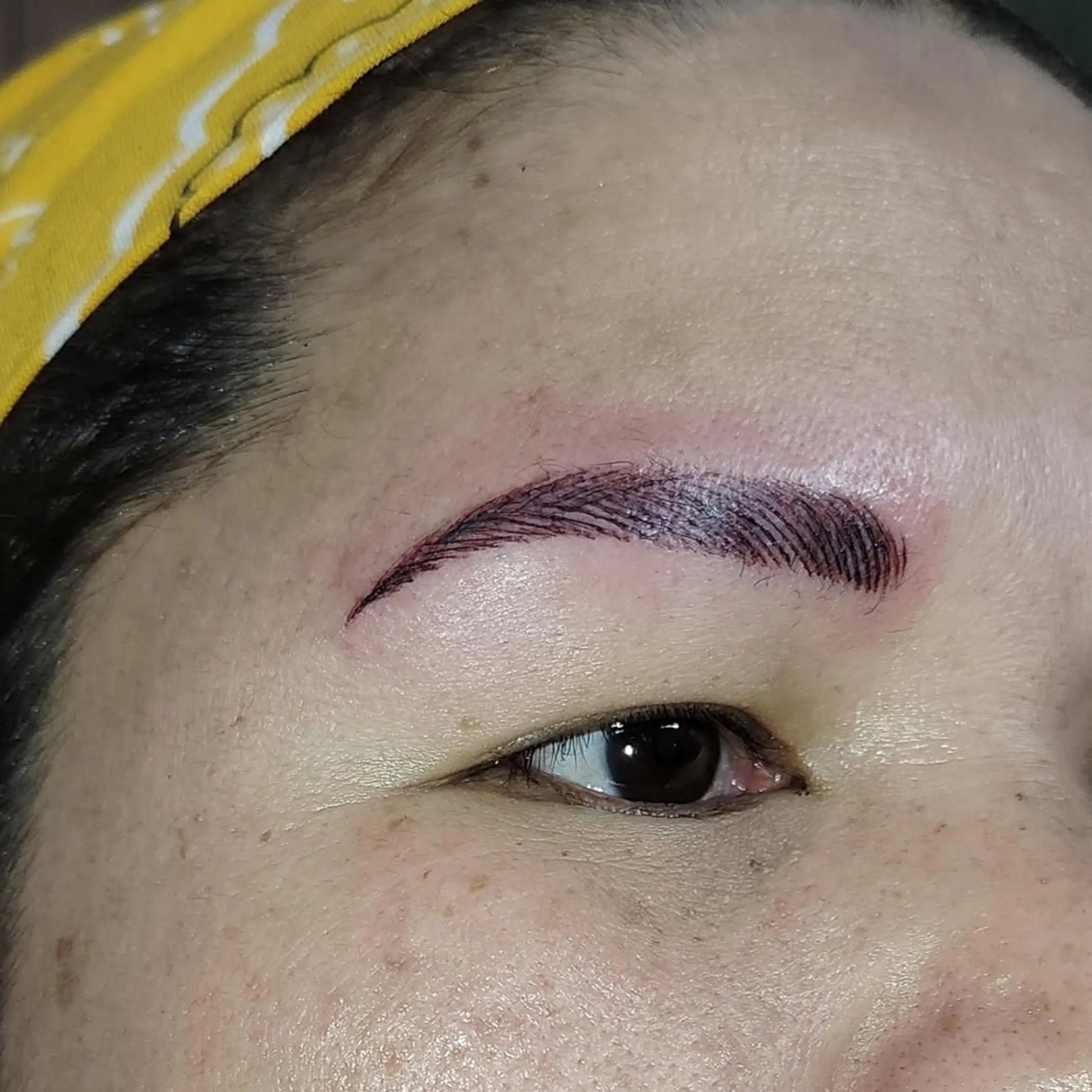 cosmetic tattoo technician shaping brows