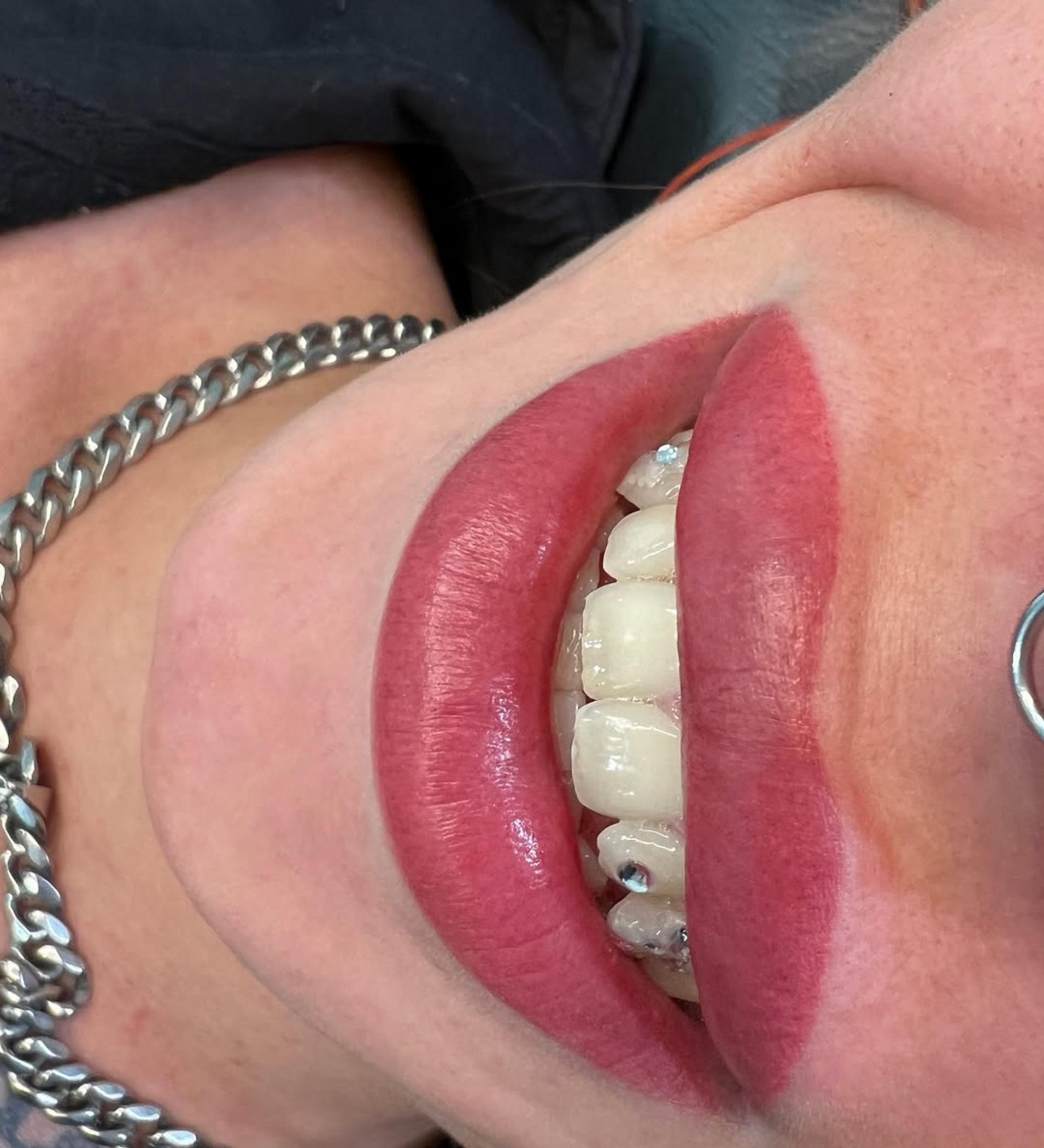 female artist shaping lips tattoo